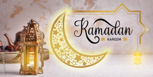 Muslim lamp and text RAMADAN KAREEM on light background photo