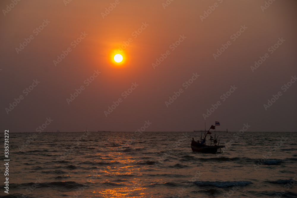 A ship sailing on the sea at sunset