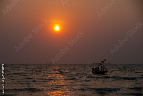 A ship sailing on the sea at sunset © Kritkamon