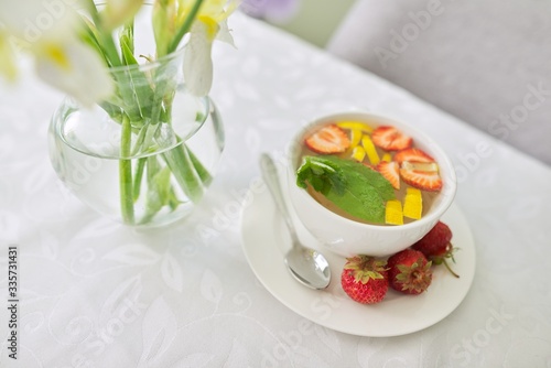 Strawberry tea with mint lemon berries on table close-up
