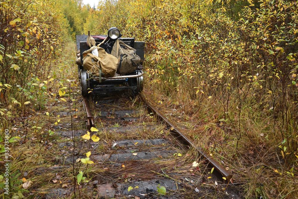 Old trolley of fishing men on an abandoned narrow-gauge railway in the heart of the Verkhnekamsk taiga.