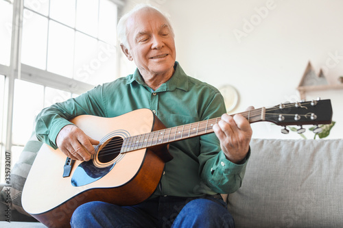 Elderly man playing guitar ...