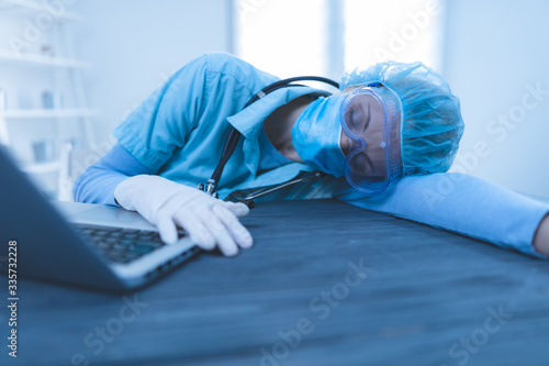 Medical doctor, nurse, surgeon, psychologist tired, sleeping from working online at home / office and helping people in the days of panic, pandemic.