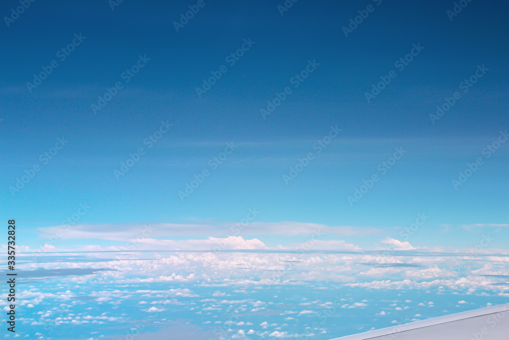 Vast bright blue sky view with clouds from airplane window, copy space