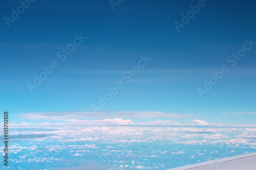 Vast bright blue sky view with clouds from airplane window, copy space