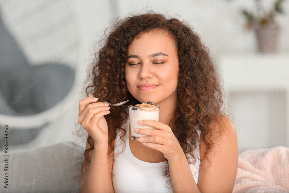 Young woman eating tasty yogurt at home Young woman eating tasty yogurt at home
