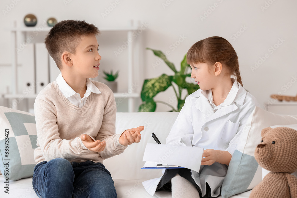 Obraz premium Cute little doctor working with patient in clinic