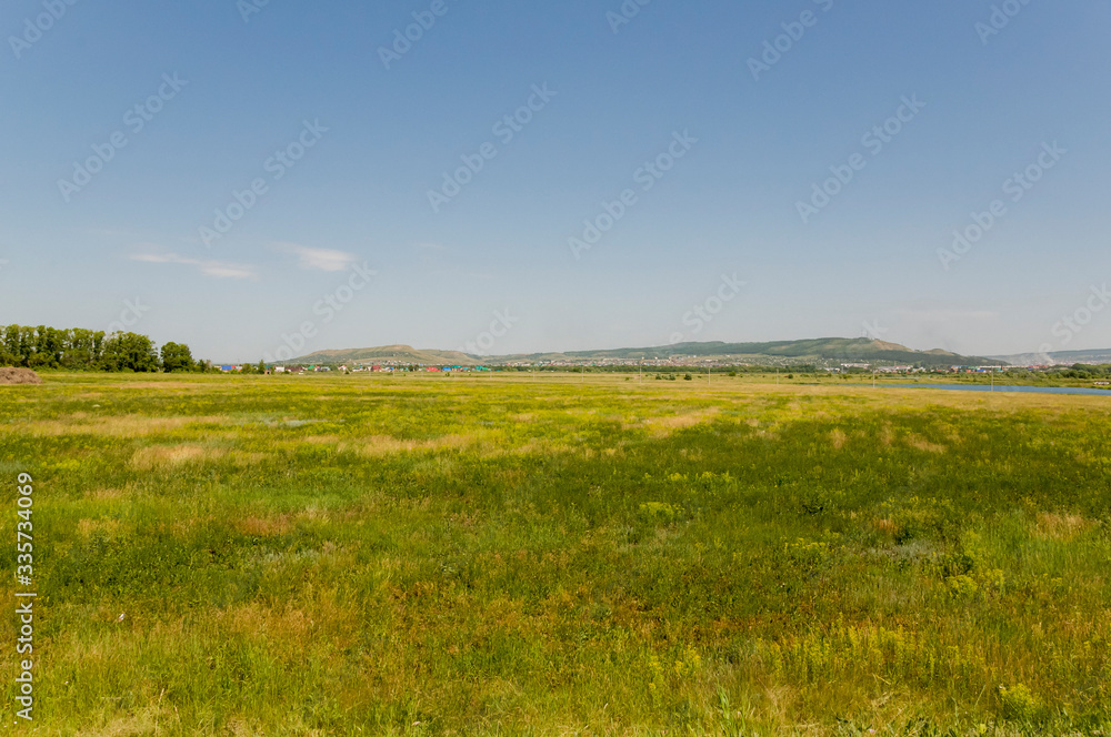 Soft landsсape with yellow meadows and forests far away. Light blue sky. Fall fields 