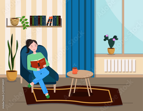 The girl is sitting in a chair and reading a book.