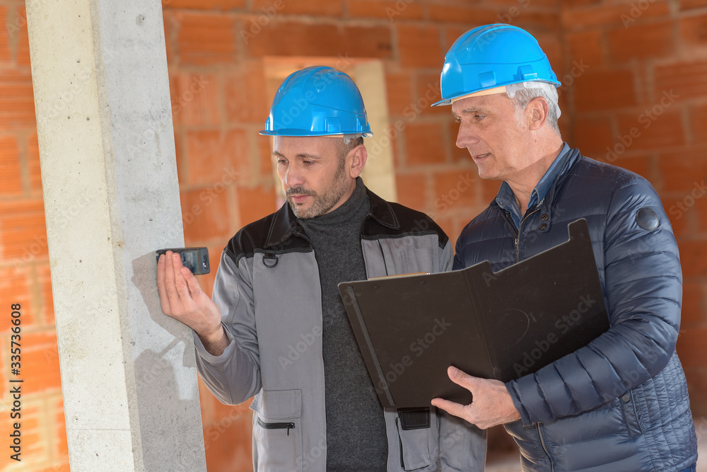 Architect is supervising the measurements in a construction site Architect is supervising the measurements in a construction site