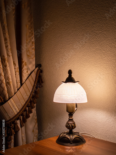 table lamp in a dark room. Cozy home interior. Reading lamp. Vertical image