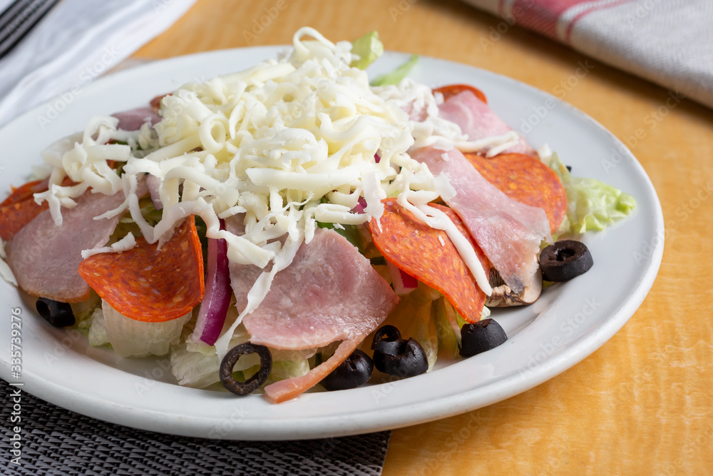 A closeup view of a plate of antipasto salad in a restaurant or kitchen setting. A closeup view of a plate of antipasto salad in a restaurant or kitchen setting.