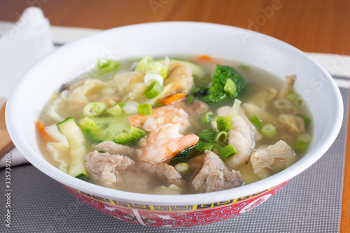 A view of a big bowl of Chinese wonton soup in a restaurant or kitchen setting.
