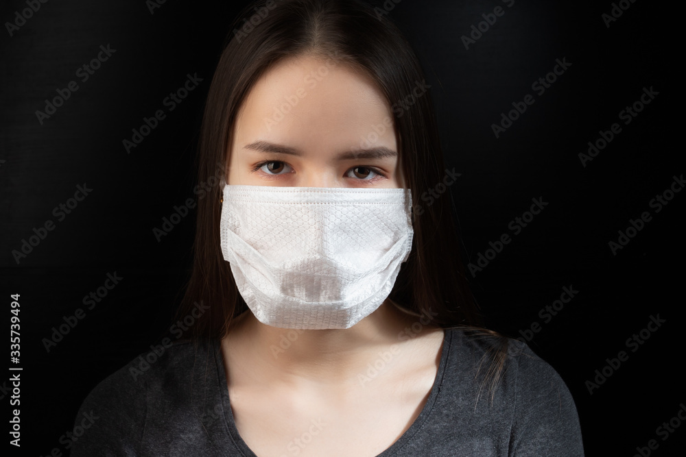 Coronavirus protection. Young woman in black antibacterial medical mask on a black background