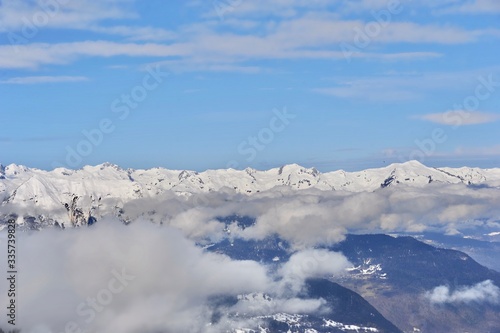 Clouds over the snowy mountain with blue sky background 