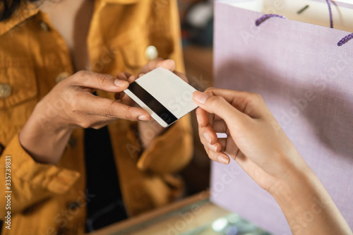 close up of hand giving credit card in the cashier before checkout photo