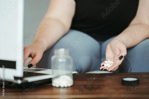 Online medical consulting. Woman looking for medicals prescription online before taking pills using laptop.