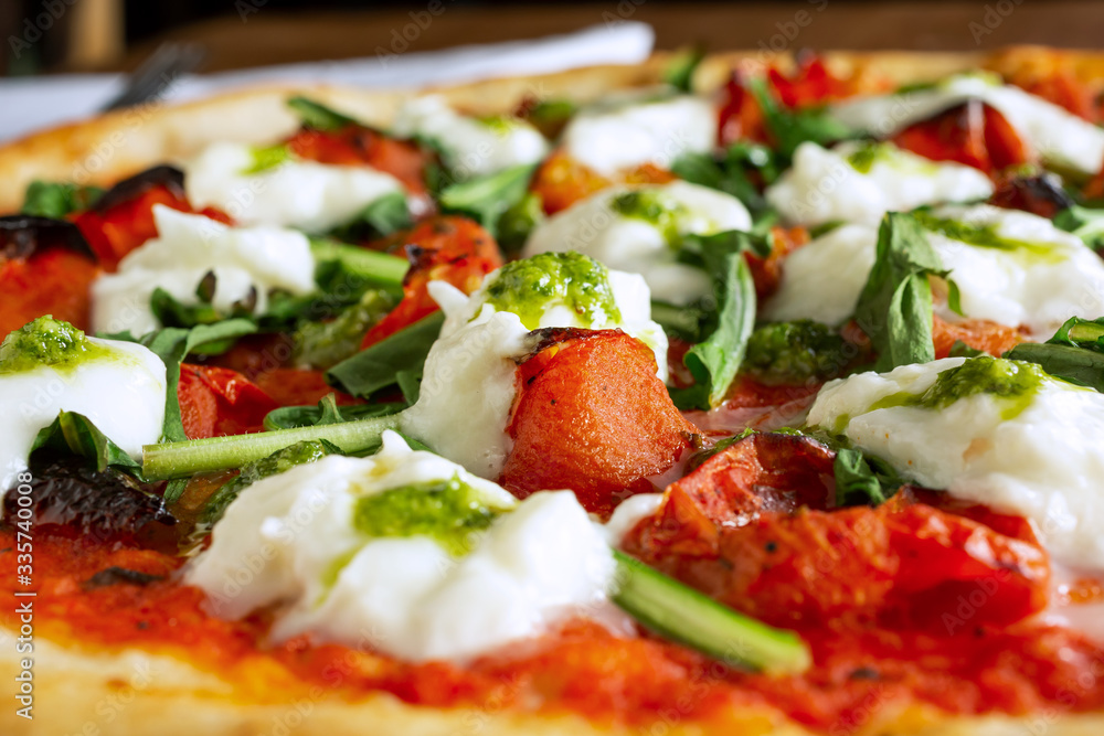 A closeup view of a margherita pizza pie, in a restaurant or kitchen setting. A closeup view of a margherita pizza pie, in a restaurant or kitchen setting.