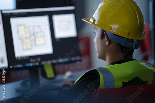 Industrial Engineering works in front of monitoring screen in the  control center office. technology and artificial intelligence concept.