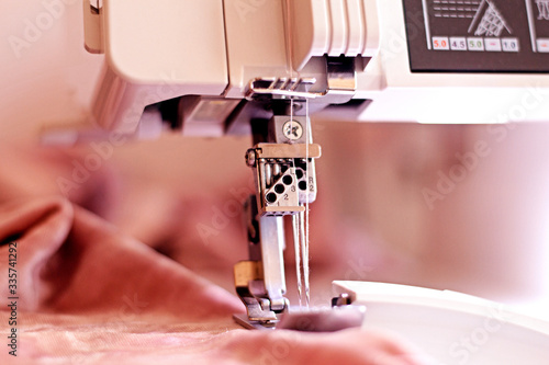 Sewing machine coverlock processes the edges of the knitted fabric with two needles photo