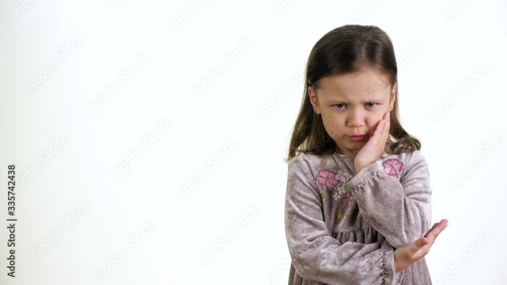 Angry child. Little cute caucasian girl looking at camera. Portrait of an angry little girl on a white background. Childhood concept. Angry child. Little cute caucasian girl looking at camera. Portrait of an angry little girl on a white background. Childhood concept.
