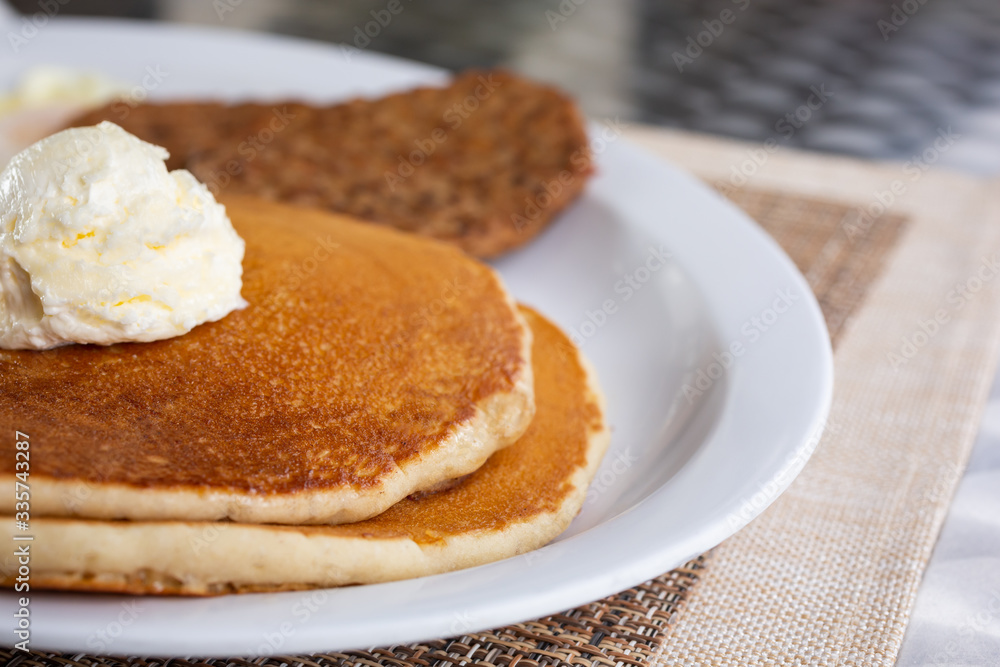 A closeup look at a plate of pancakes in a restaurant or kitchen setting. A closeup look at a plate of pancakes in a restaurant or kitchen setting.