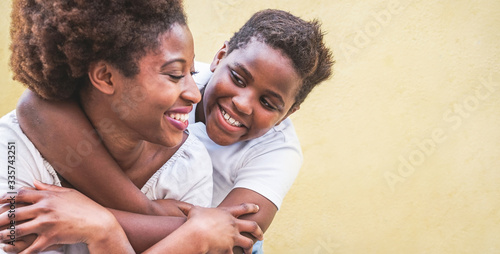 Happy young mother having fun with her kid - Son hugging his mum outdoor - Family connection, motherhood, love and tender moments concept - Focus on boy face