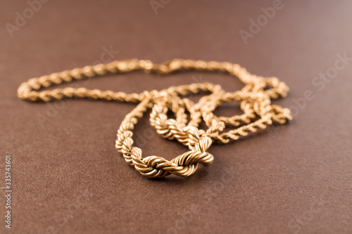 Gold chain on a brown background. Selective focus. Macro.