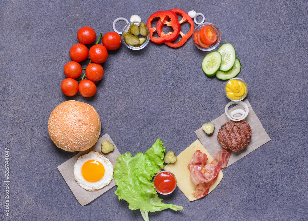Frame made of ingredients for tasty burger on dark background Frame made of ingredients for tasty burger on dark background
