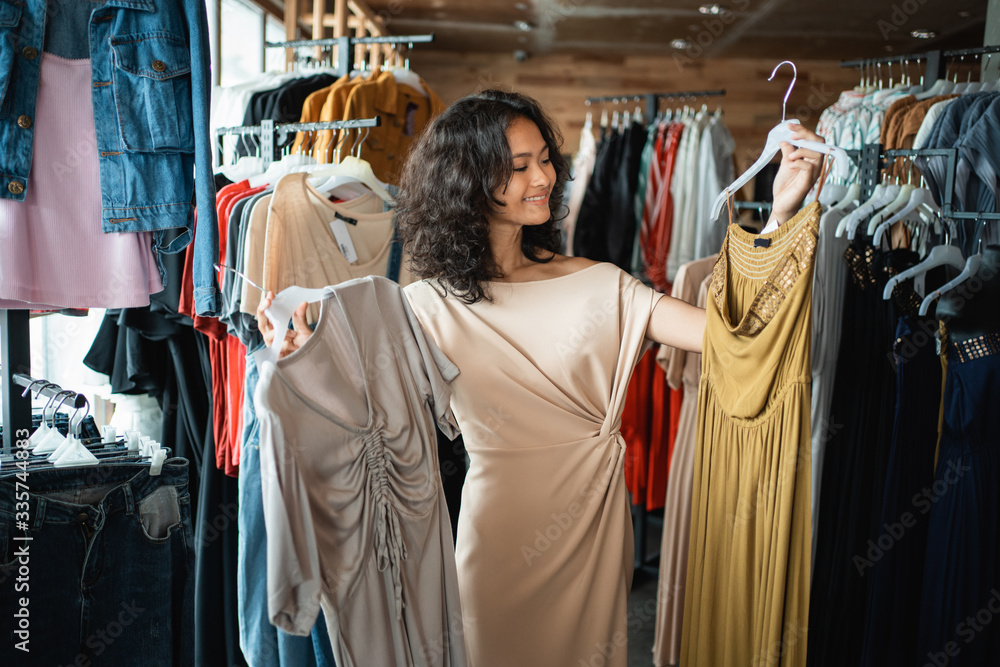 beautiful asian woman looking at some clothes in the fashion store. shopping concept beautiful asian woman looking at some clothes in the fashion store. shopping concept