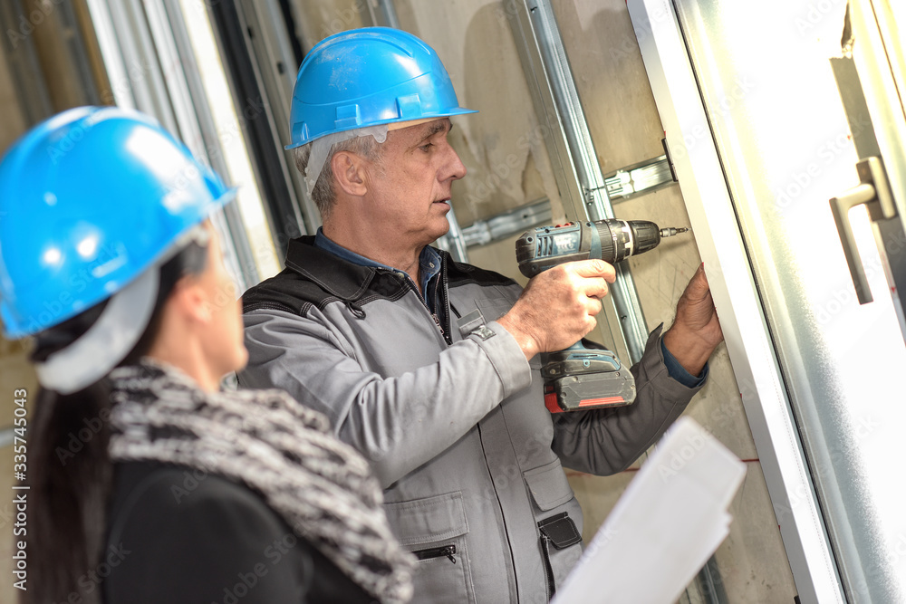 The worker finishes screwing with his electric screwdrivers The worker finishes screwing with his electric screwdrivers