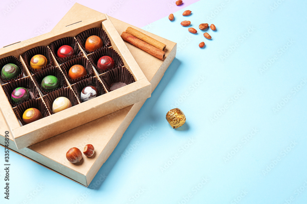 Box with delicious chocolate candies on color background Box with delicious chocolate candies on color background