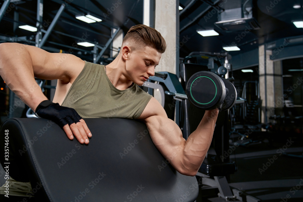Muscular man building biceps with dumbbell. Muscular man building biceps with dumbbell.