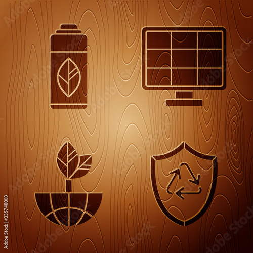 Set Recycle symbol inside shield, Recycling plastic bottle, Earth globe and leaf and Solar energy panel on wooden background. Vector