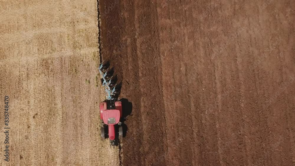 a redder tractor plows a field a redder tractor plows a field