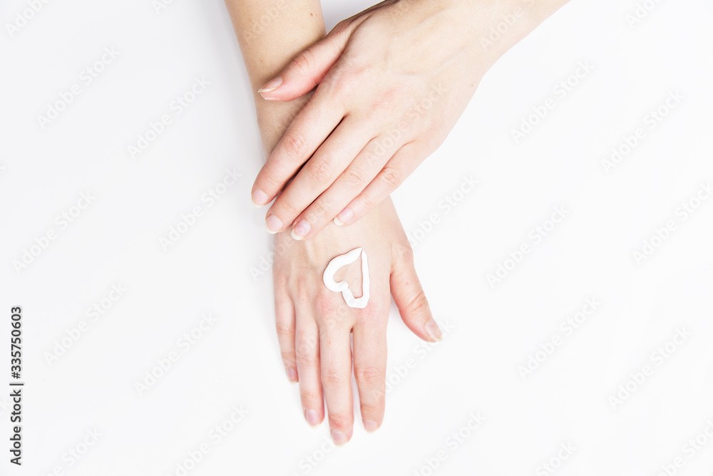 Obraz premium Woman hands with creame skin care, heart symbol on her hand