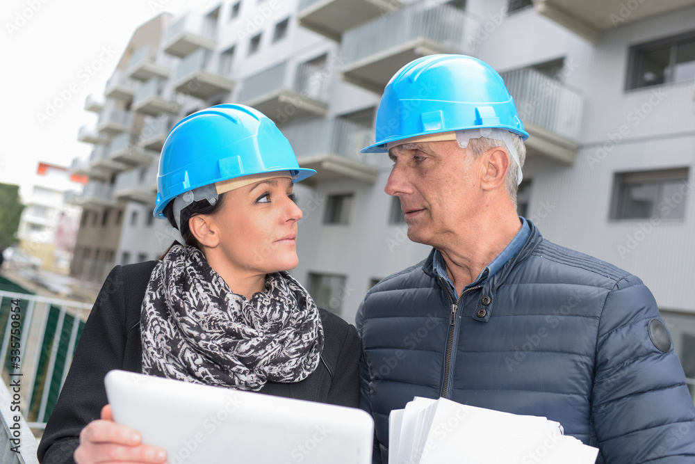 Construction manager and architect are reading their notes on a site Construction manager and architect are reading their notes on a site