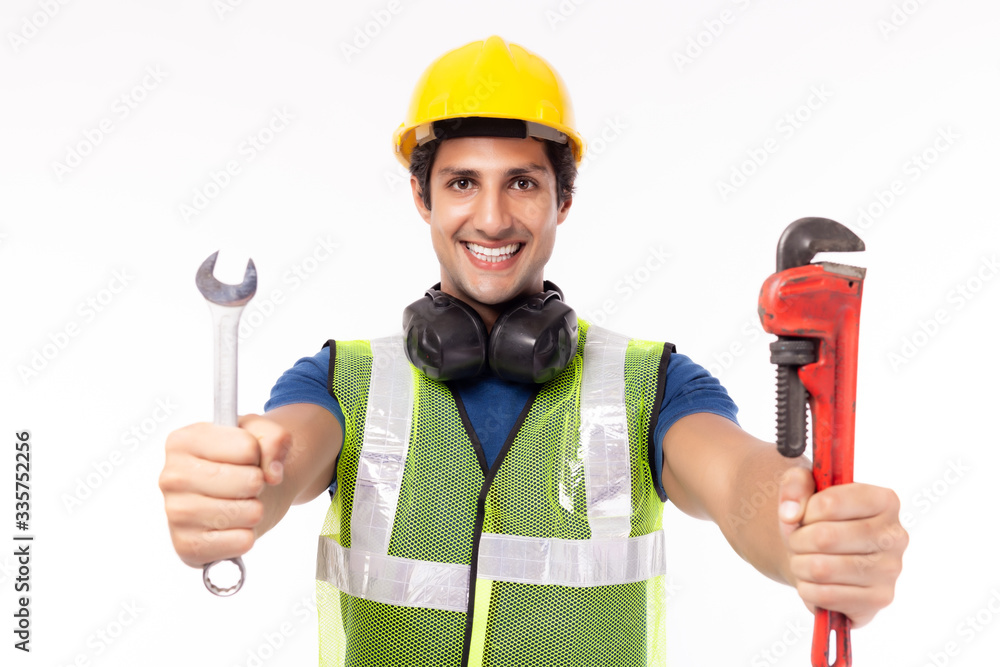 Industrial engineer man ready for work. Factory man worker wear hardhat, reflective vest. Handsome young industry engineer guy working in industry manufacturing factory. He fix or repair everything Industrial engineer man ready for work. Factory man worker wear hardhat, reflective vest. Handsome young industry engineer guy working in industry manufacturing factory. He fix or repair everything