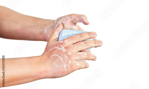 Young man wash hands with soapbar, closeup detail on soap bubbles, isolated on white. Can be used during coronavirus covid-19 outbreak prevention