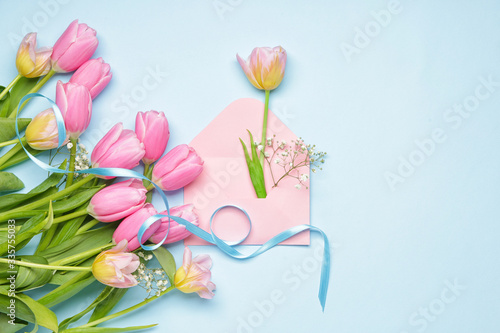 Beautiful flowers and envelope on color background
