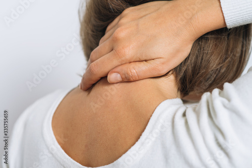 Fotografija Close Up portrait stressed unhappy, young pretty woman with bad chronic neck pai