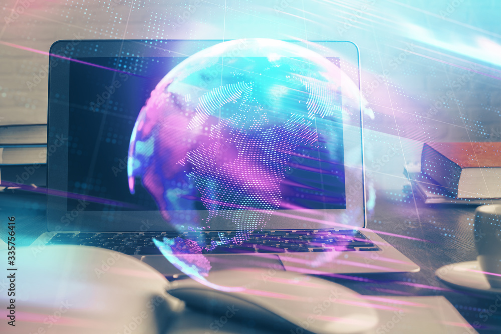 Obraz premium Computer on desktop in office with technology theme hologram. Multi exposure. Tech concept.