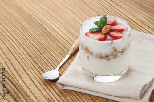 a cup of yogurt and strawberries on the table
