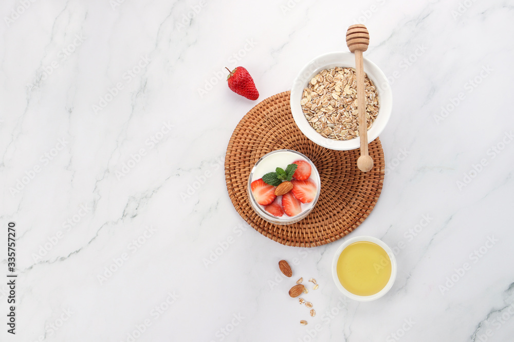 a cup of yogurt and strawberries on the table
