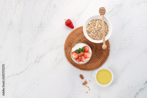 a cup of yogurt and strawberries on the table
