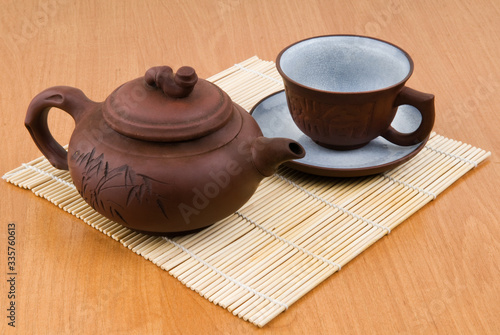 A tea cup on a saucer and a tea kettle