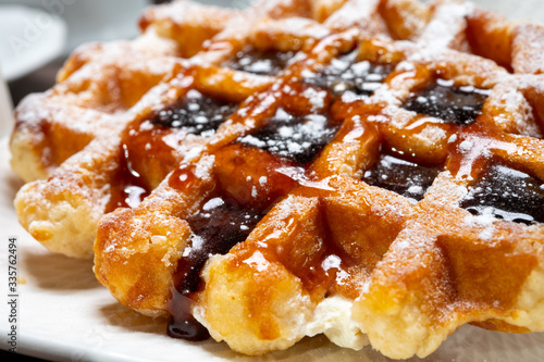 Tasty Belgian dessert, Brussels waffles with syrup and white sugar powder