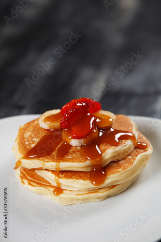 tasty pancakes with banana, strawberry and sauce