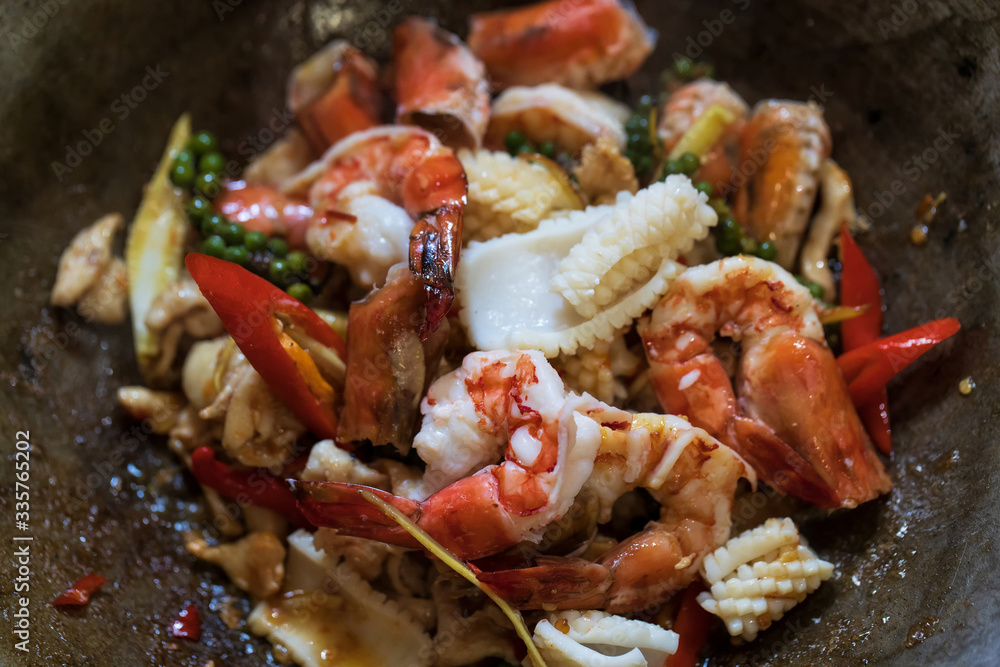 Selective focus of fried stir spicy sea food in pan, Pad Cha Talay Sea Food, Thai food. Close up Selective focus of fried stir spicy sea food in pan, Pad Cha Talay Sea Food, Thai food. Close up