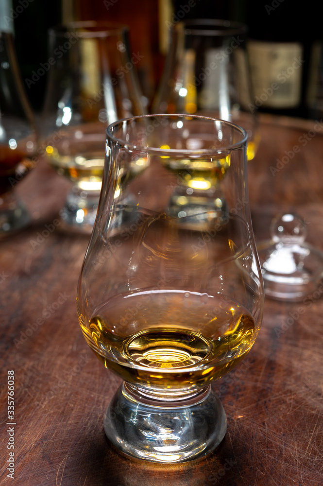 Tasting of flight of Scotch whisky from special tulip-shaped glasses on distillery in Scotland, UK Tasting of flight of Scotch whisky from special tulip-shaped glasses on distillery in Scotland, UK